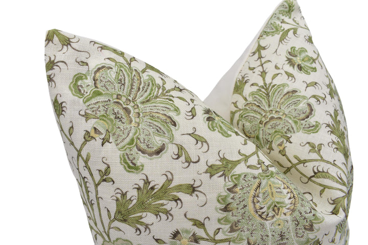 a green and white pillow with a flower design