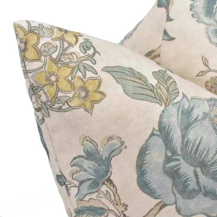 a close-up view of a decorative pillow with a floral pattern in shades of blue and green.