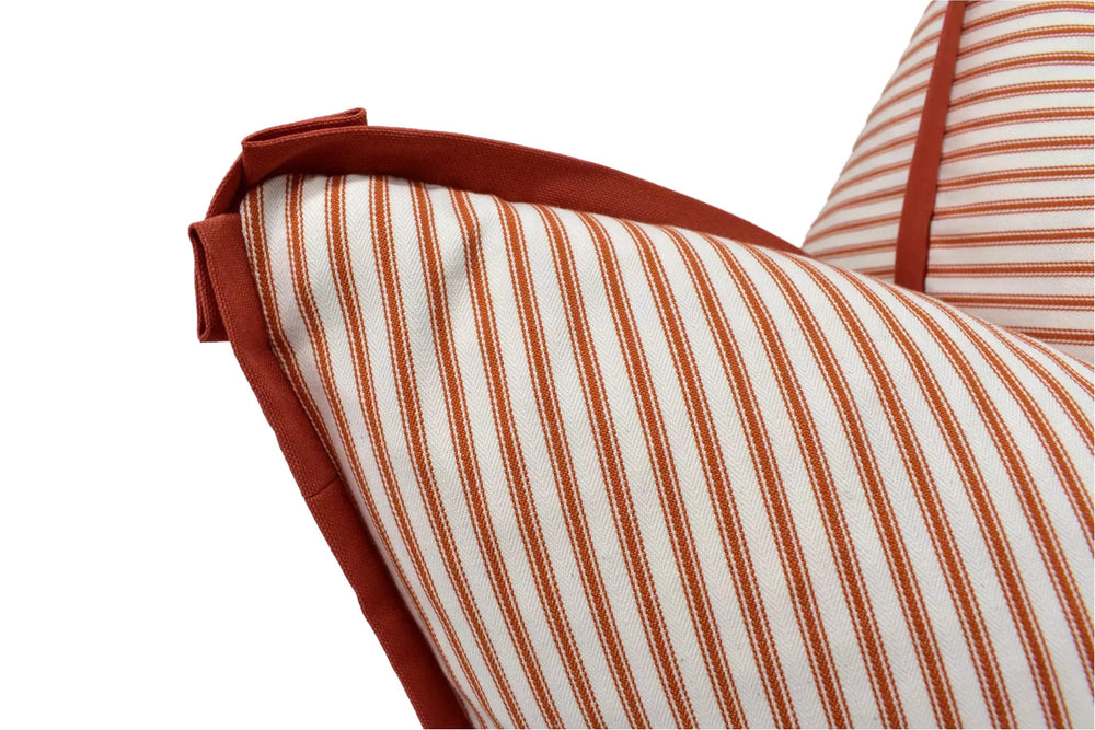 a close-up view of a striped cushion with a red trim.