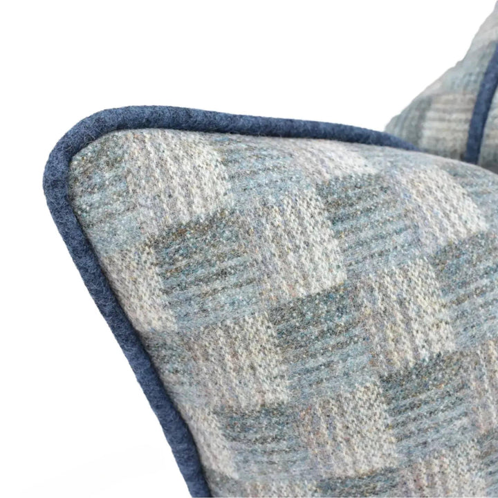 a close-up view of a blue and gray patterned pillow with a dark blue border.