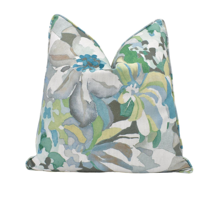 a blue and green floral pillow on a white background