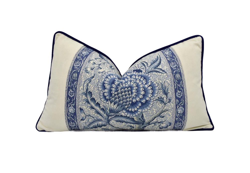 A decorative pillow with a blue and white floral pattern.
