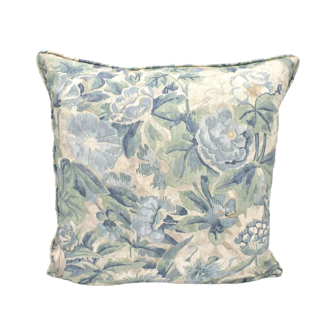 A decorative throw pillow with a floral print in shades of blue and green.