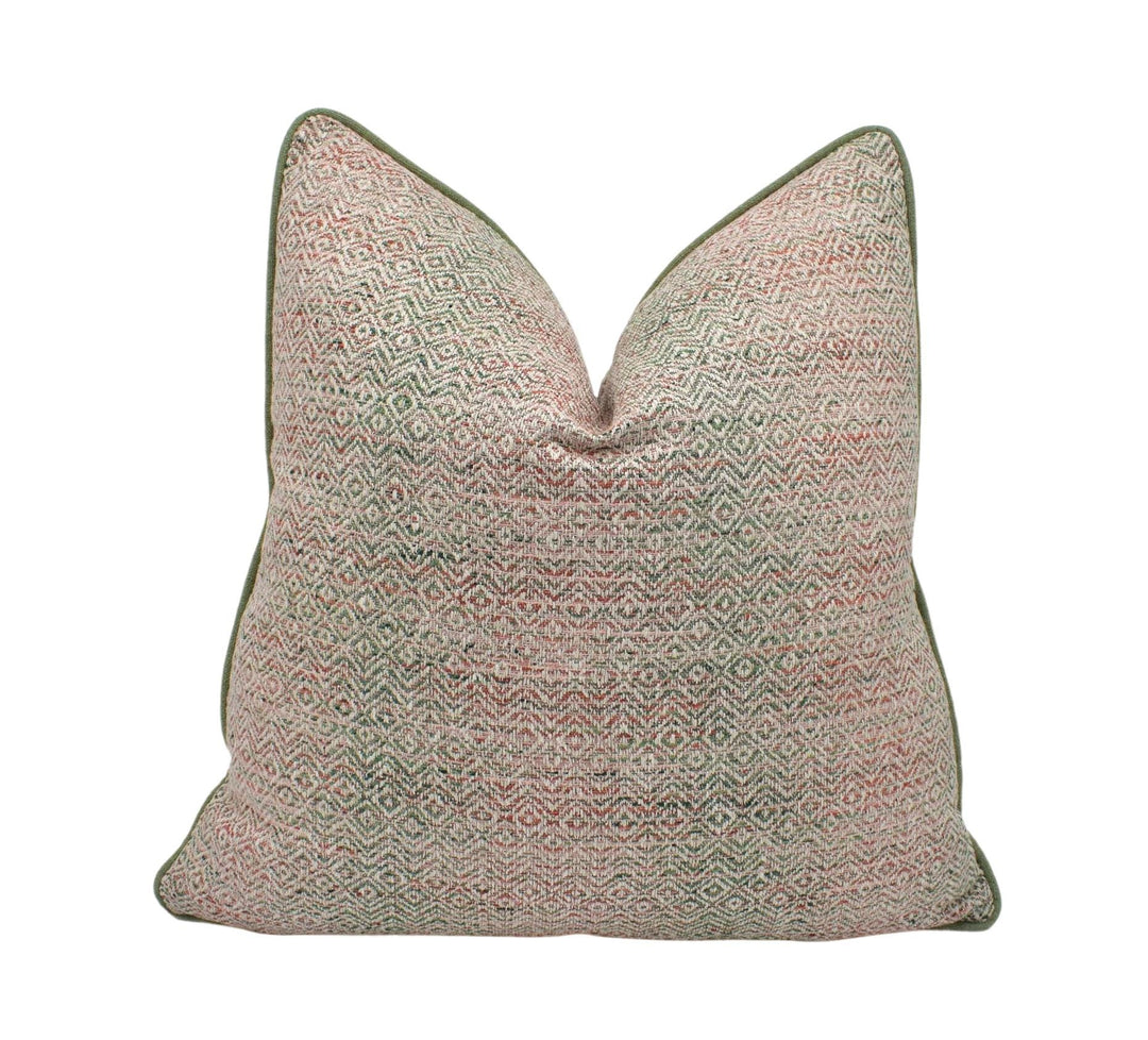 a pink and green pillow on a white background