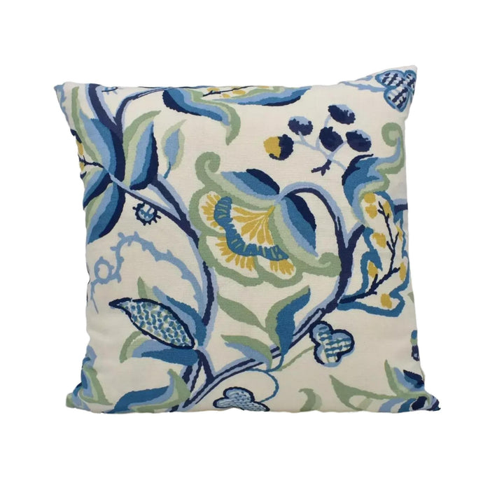 a square throw pillow with a floral pattern in shades of blue, green, and yellow.