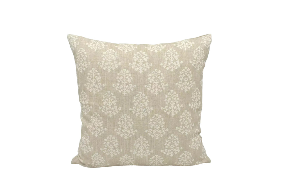 A beige throw pillow with a repeating pattern of white flowers or leaves is displayed against a white background.
