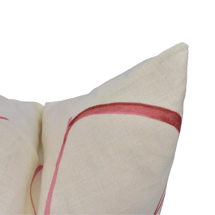 A close-up view of a white pillow with a red stripe, against a white background.