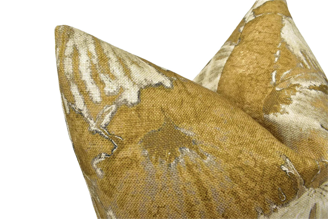 a close-up view of a textured fabric, possibly a pillow or cushion, with a gold and white pattern.