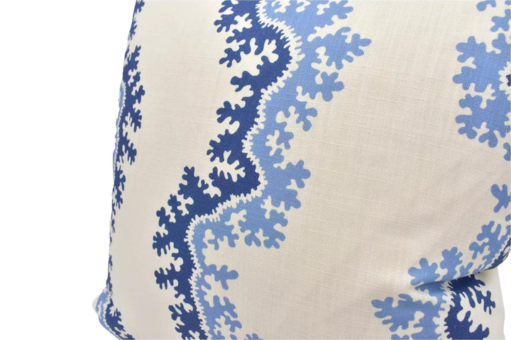 A close-up view of a decorative pillow with a blue and white floral pattern.