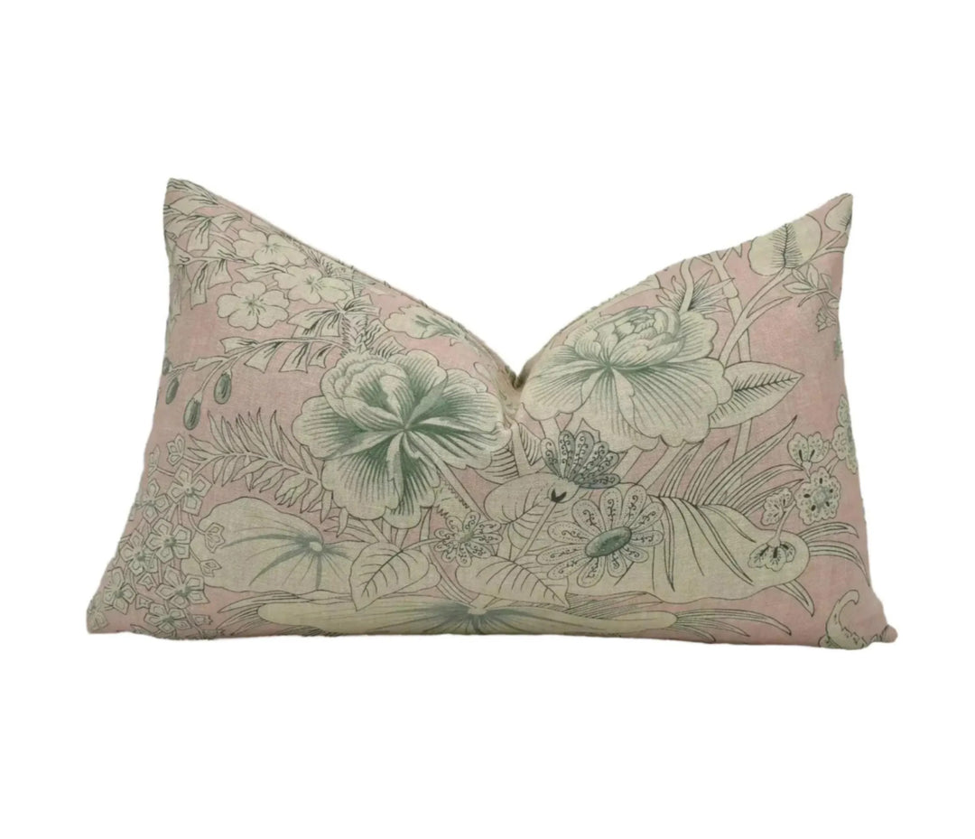 A decorative pillow with a floral pattern in shades of pink and green.
