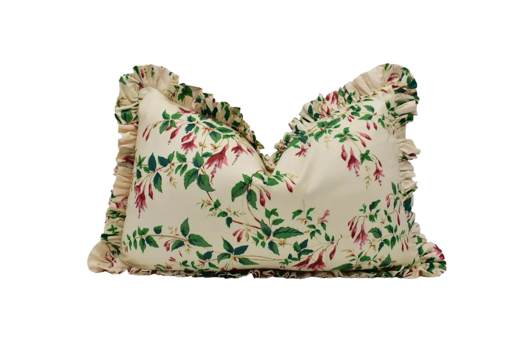 A decorative pillow with a floral print in shades of green and red.