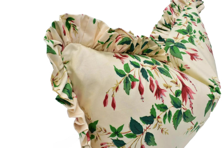 A close-up image of a decorative pillow with a floral print in shades of green and red.
