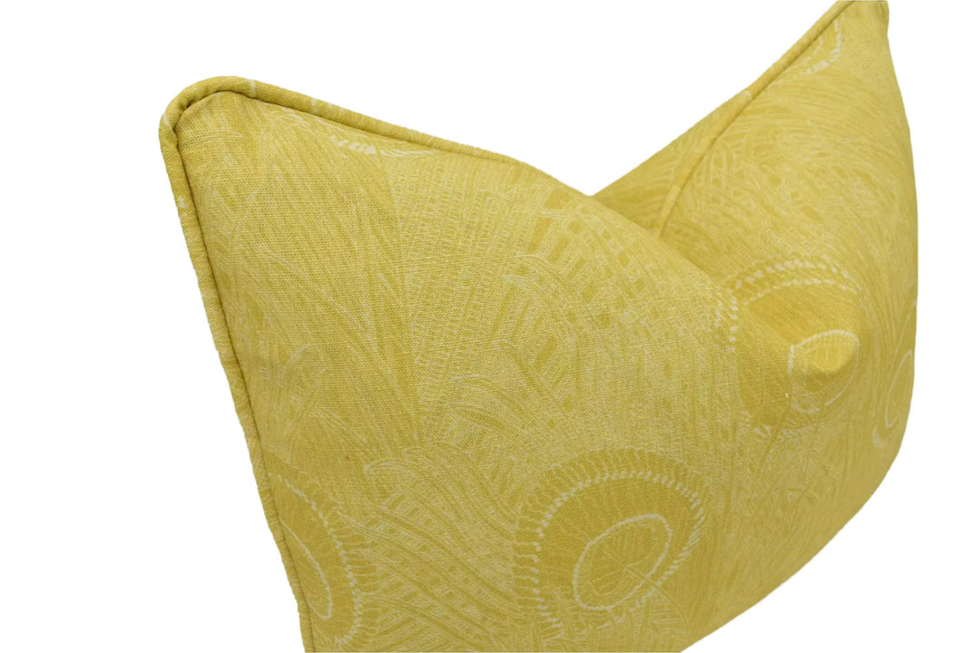 A yellow decorative pillow with a leaf pattern design.