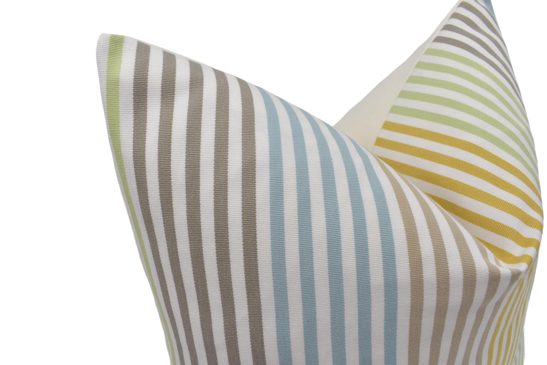 a close-up view of a colorful striped pillow with a mix of green, blue, and yellow stripes.