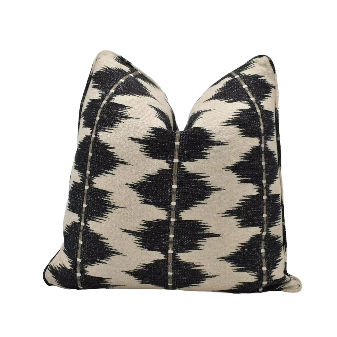 A black and white patterned throw pillow with a geometric design.