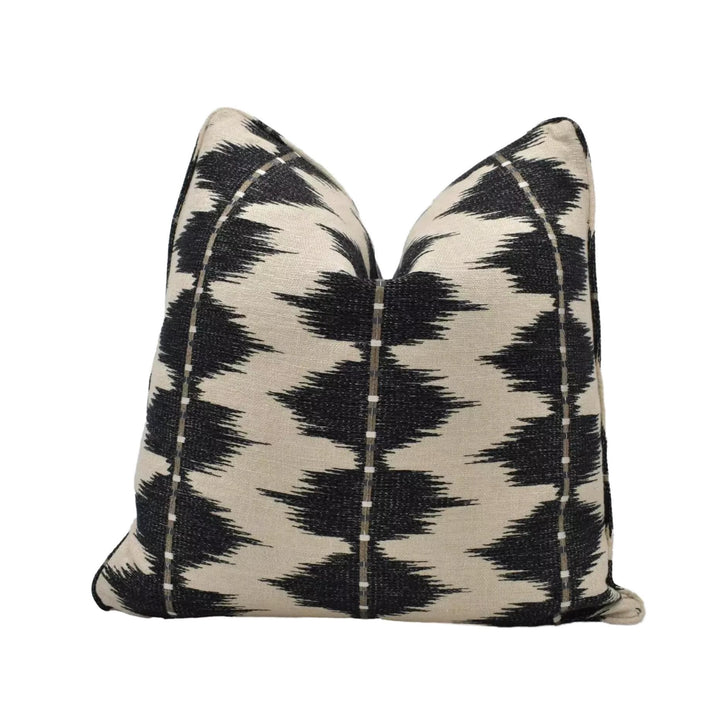 A black and white patterned throw pillow with a geometric design.