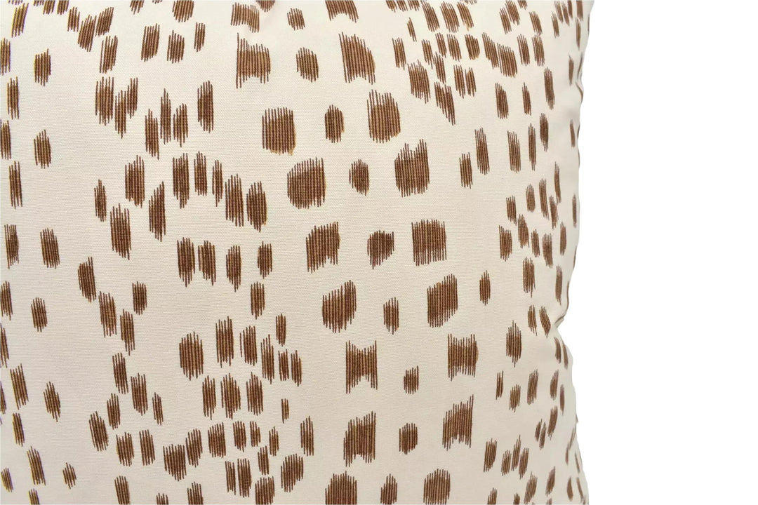a close-up view of a beige fabric with a brown spotted pattern.