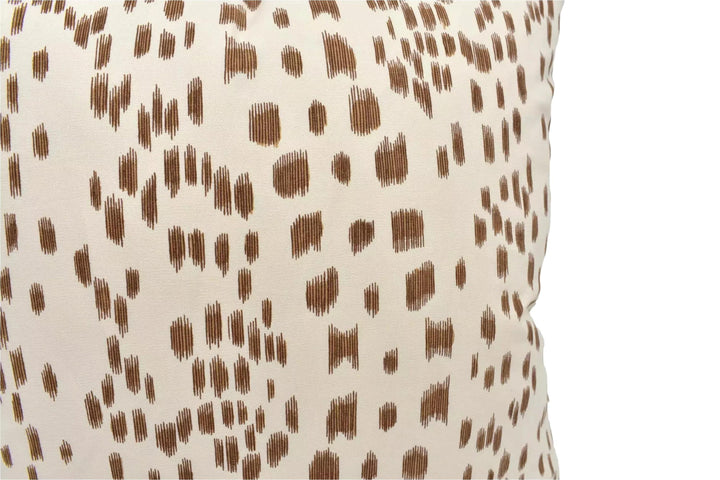 a close-up view of a beige fabric with a brown spotted pattern.
