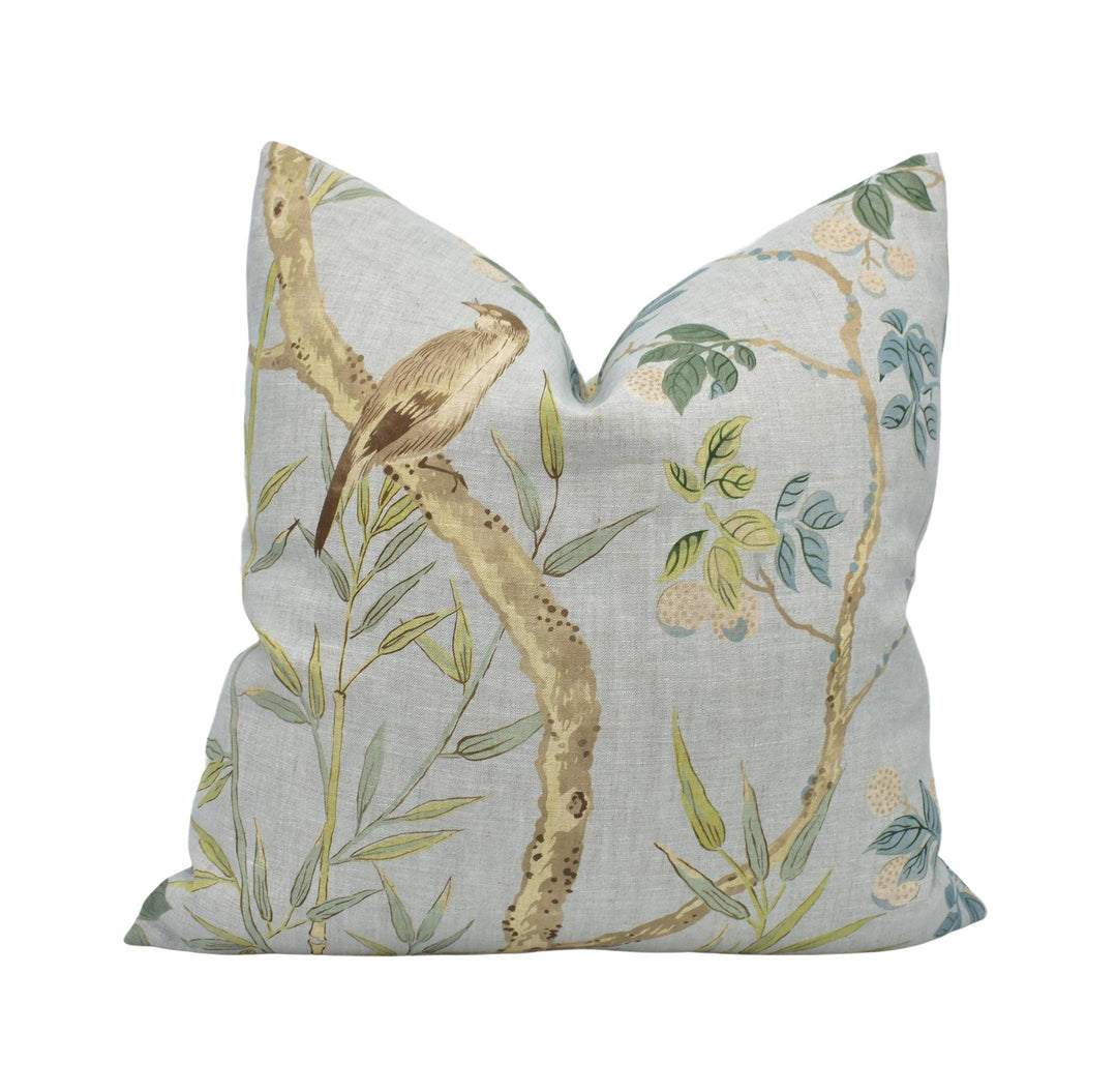 a pillow with a bird sitting on a branch