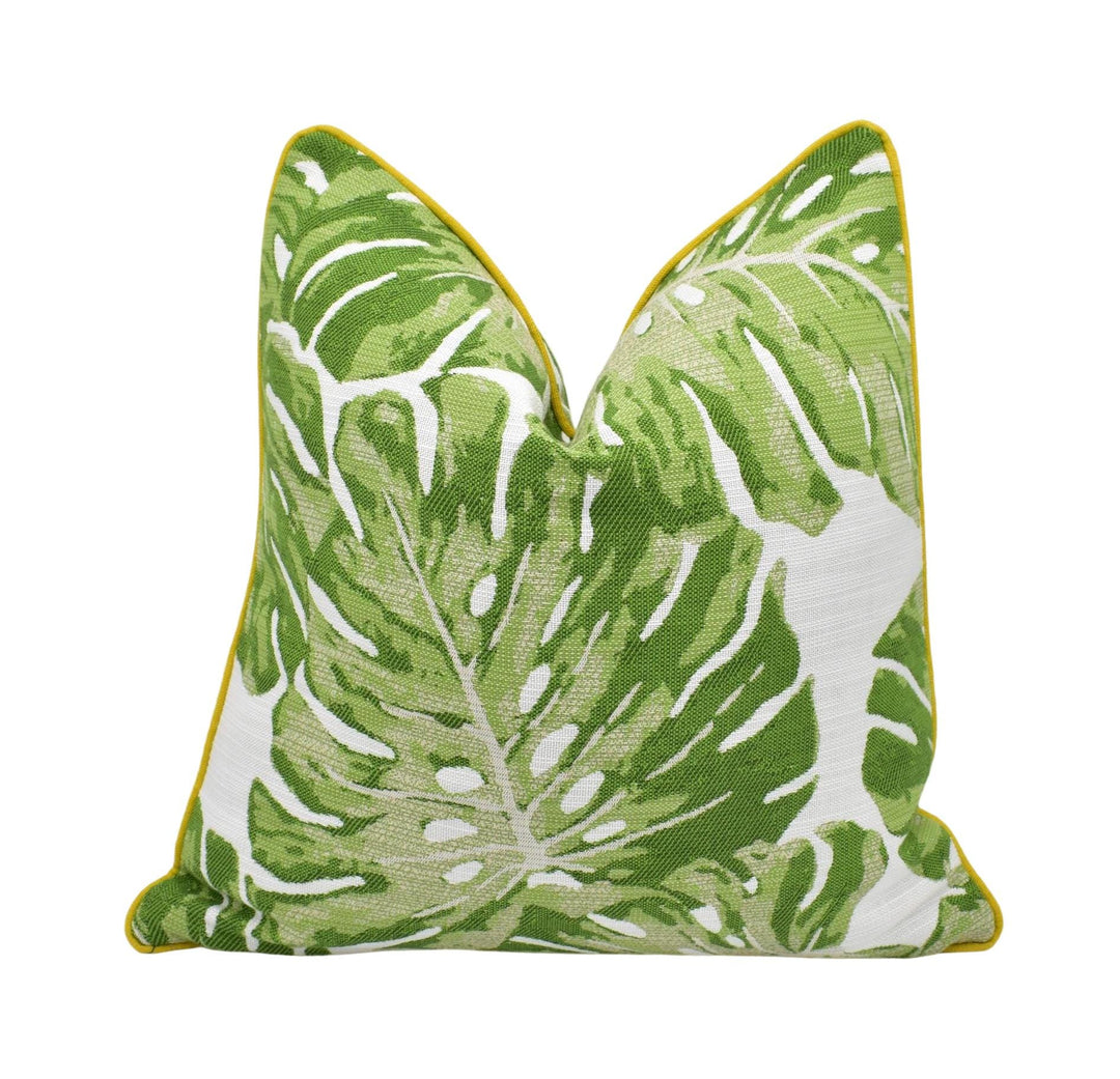 A green and white throw pillow with a leaf pattern design.