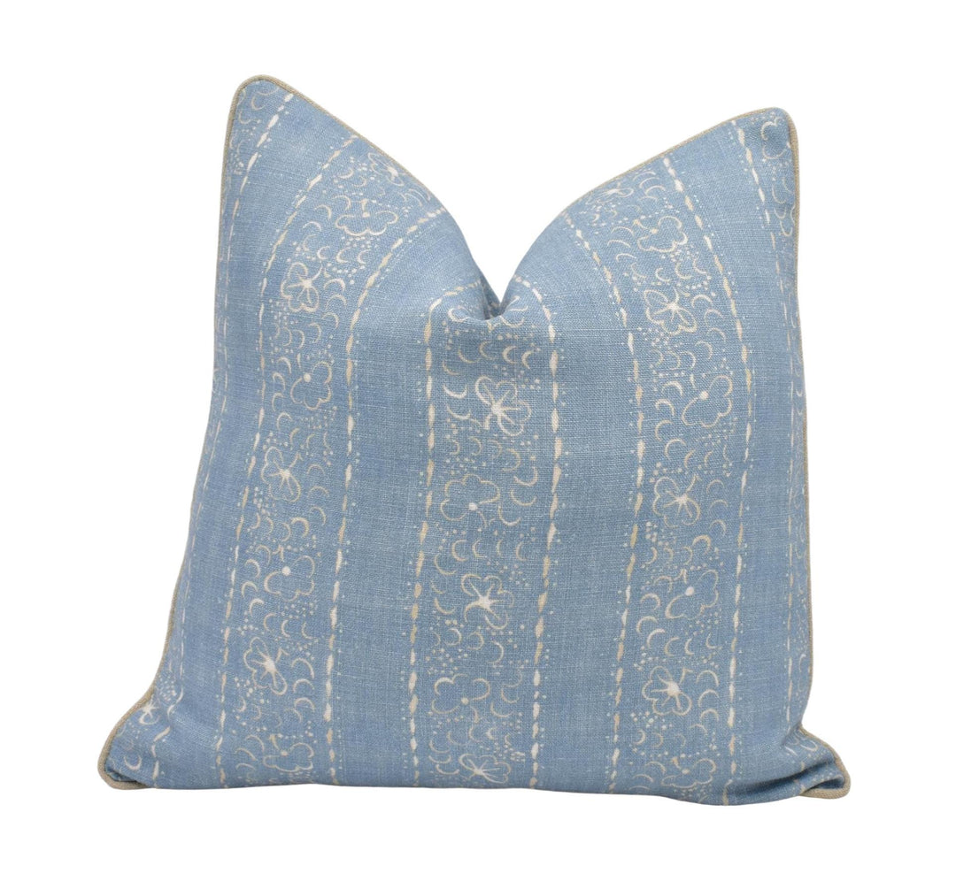 A blue and white striped pillow with a floral pattern.