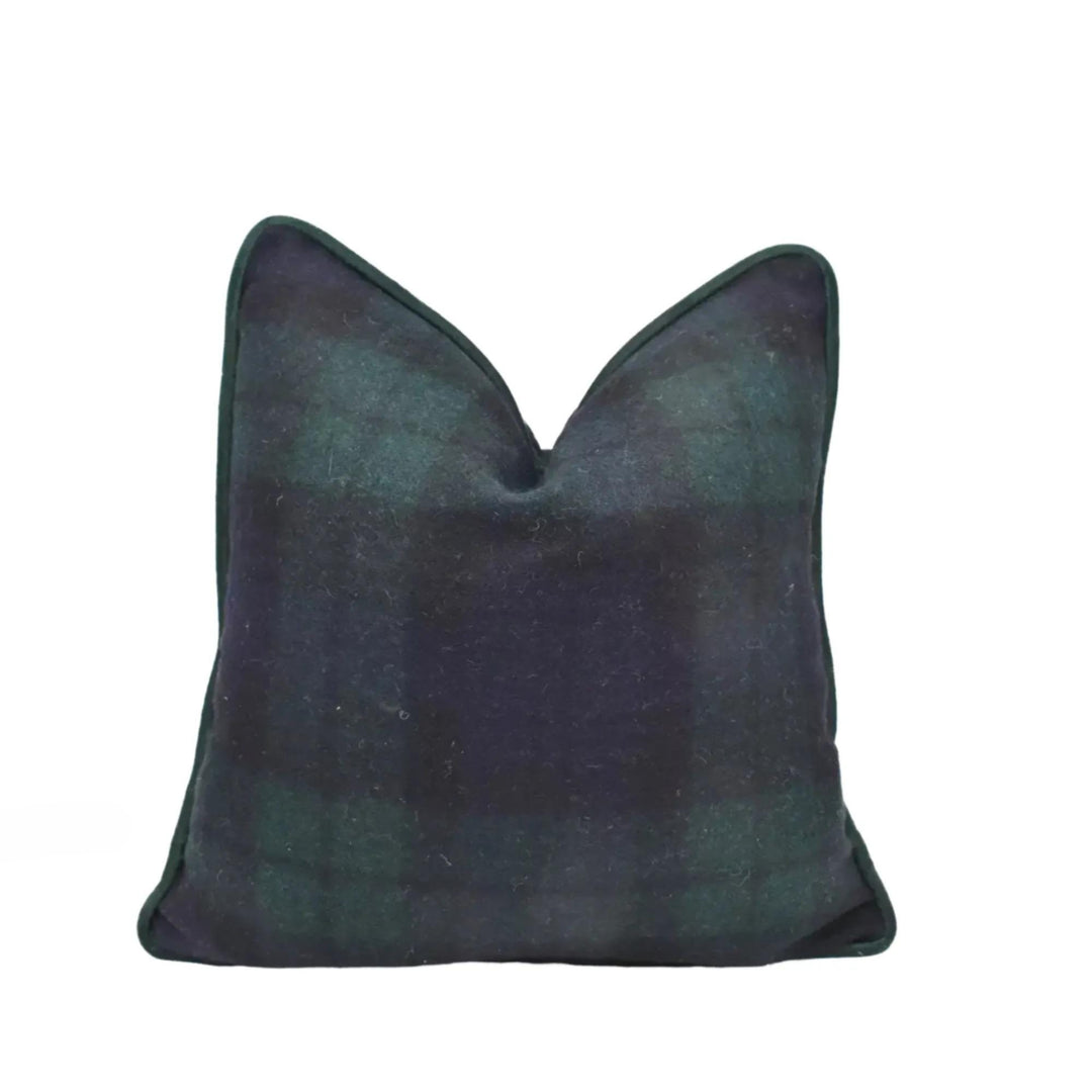 A dark green plaid throw pillow with a pointed top and a dark green border.