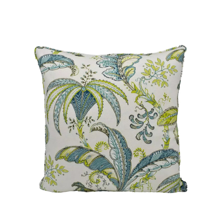 A decorative throw pillow with a tropical leaf pattern in shades of green and blue.