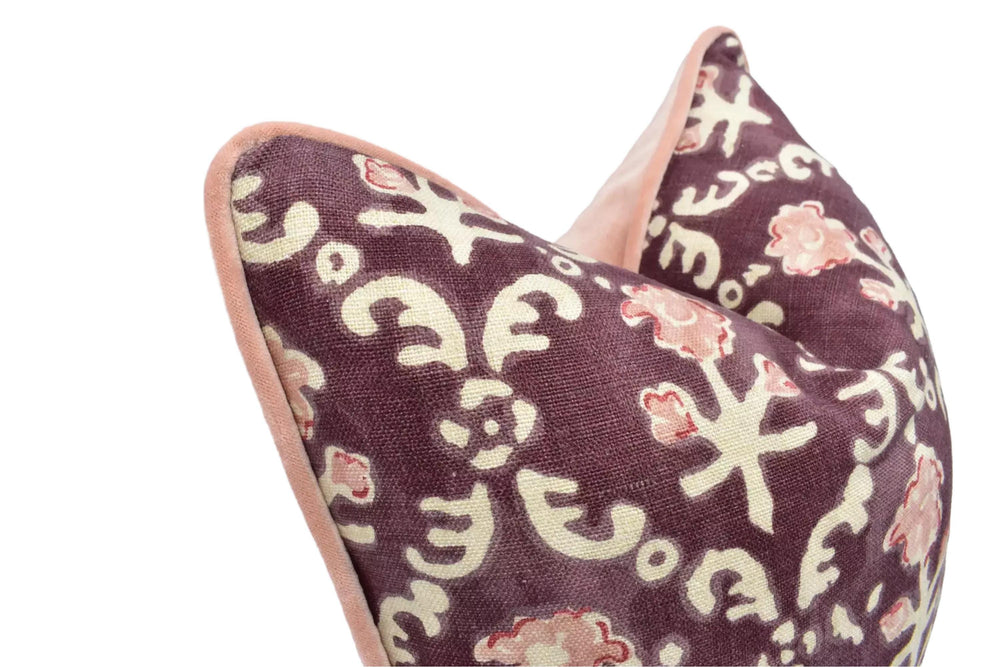 a close-up view of a decorative pillow with a floral pattern in shades of purple and pink.