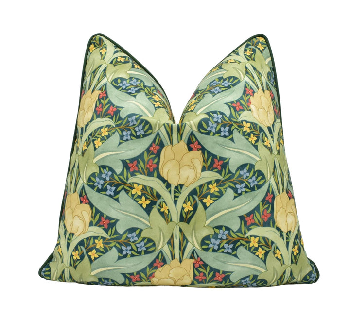 a green pillow with yellow and blue flowers on it
