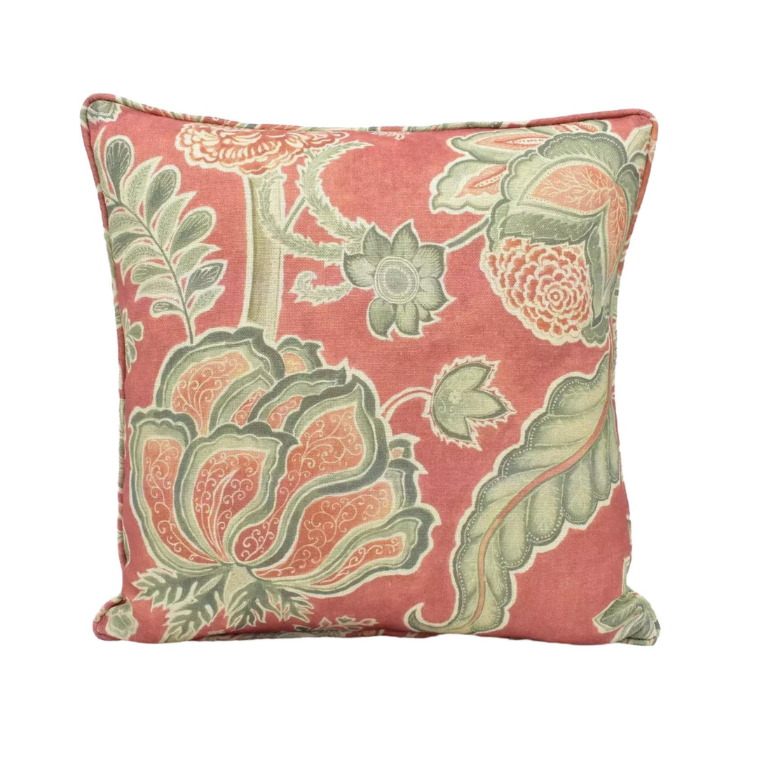 A square throw pillow with a floral pattern in shades of red, green, and white.