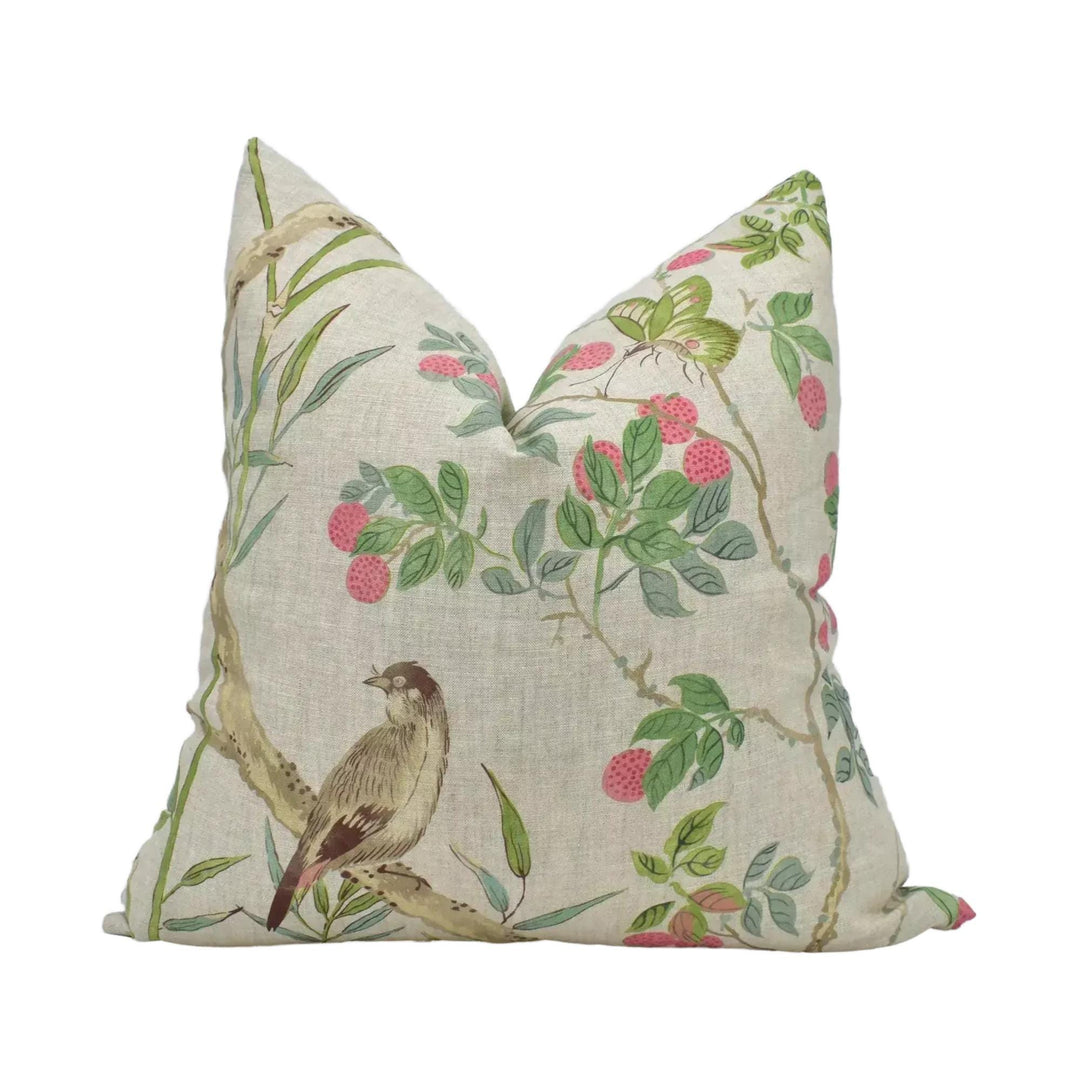 A beige pillow with a floral print design featuring a bird, flowers, and leaves.