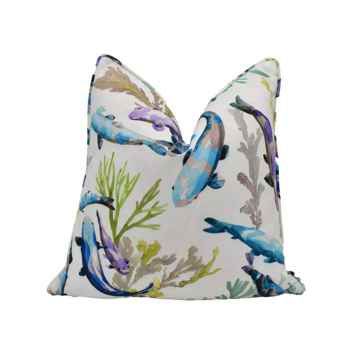 a white pillow with a vibrant, colorful print of fish and aquatic plants on it.