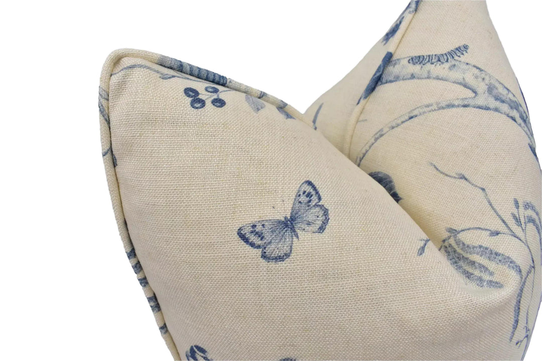 a close-up view of a beige fabric with a blue butterfly design.