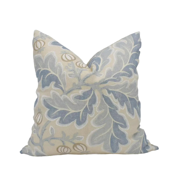 A decorative throw pillow with a floral pattern in shades of blue and gray.