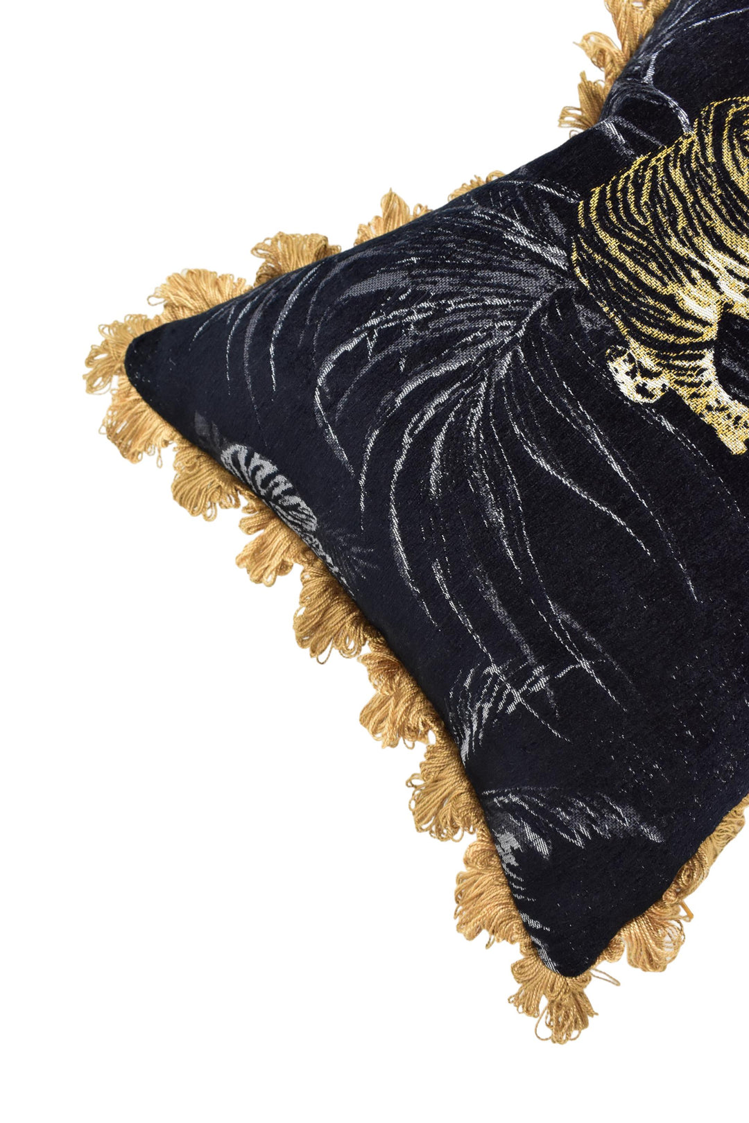 A close-up view of a decorative pillow with a black and gold tiger pattern, featuring a tassel fringe at the edges.