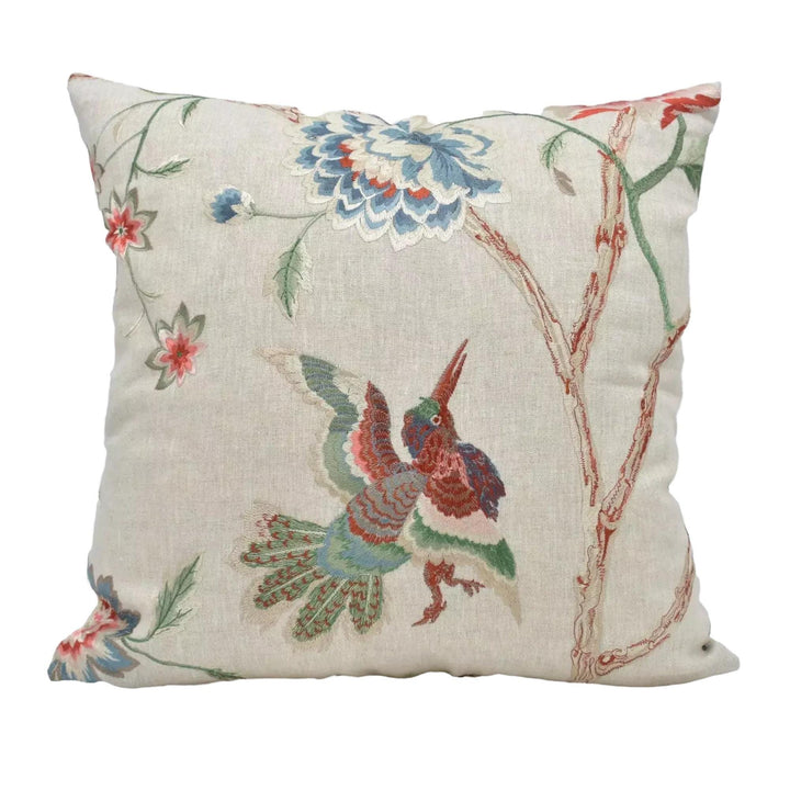 A decorative throw pillow with a floral and bird motif.