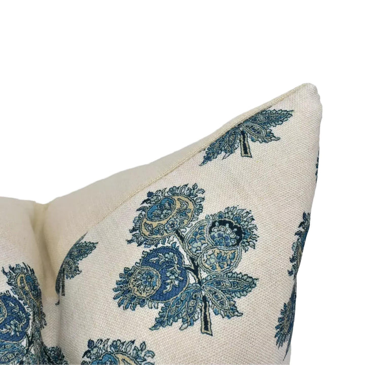 A close-up view of a decorative pillow with a floral pattern in shades of blue and green.