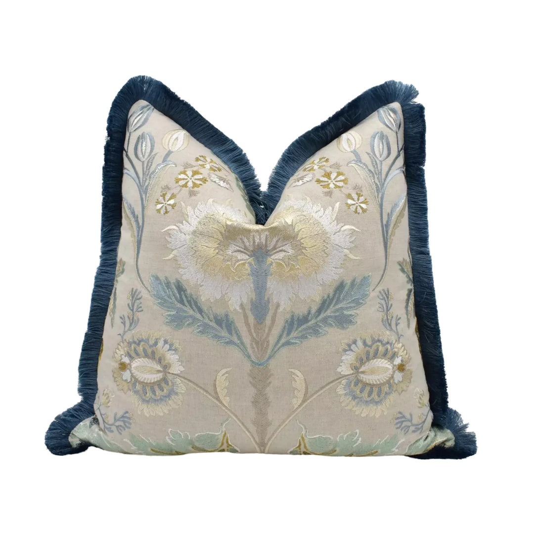 A decorative throw pillow with a floral pattern in shades of blue and white, featuring a central design surrounded by smaller floral motifs.
