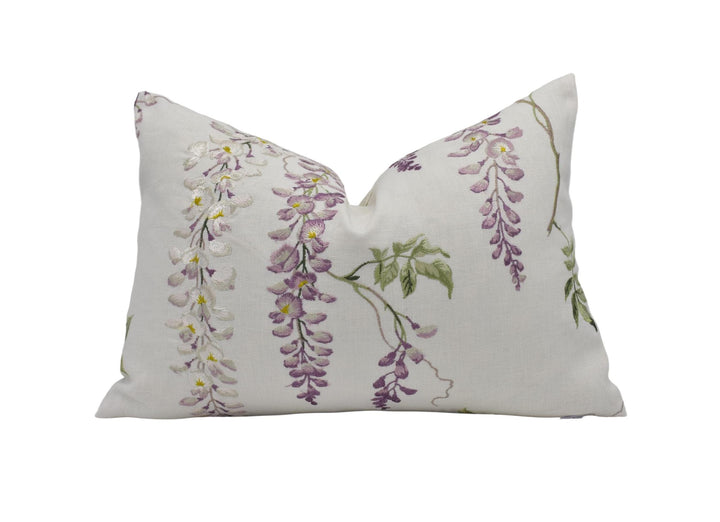 A white pillow with a floral print design featuring purple and green flowers.