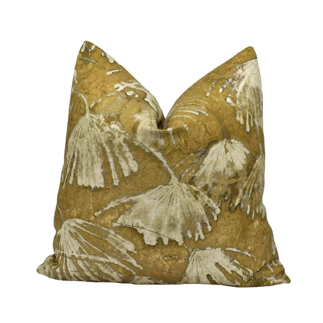 a decorative pillow with a leafy pattern in shades of brown and beige.