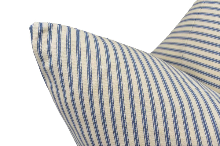 A close-up view of a striped pillow with blue and white vertical stripes.