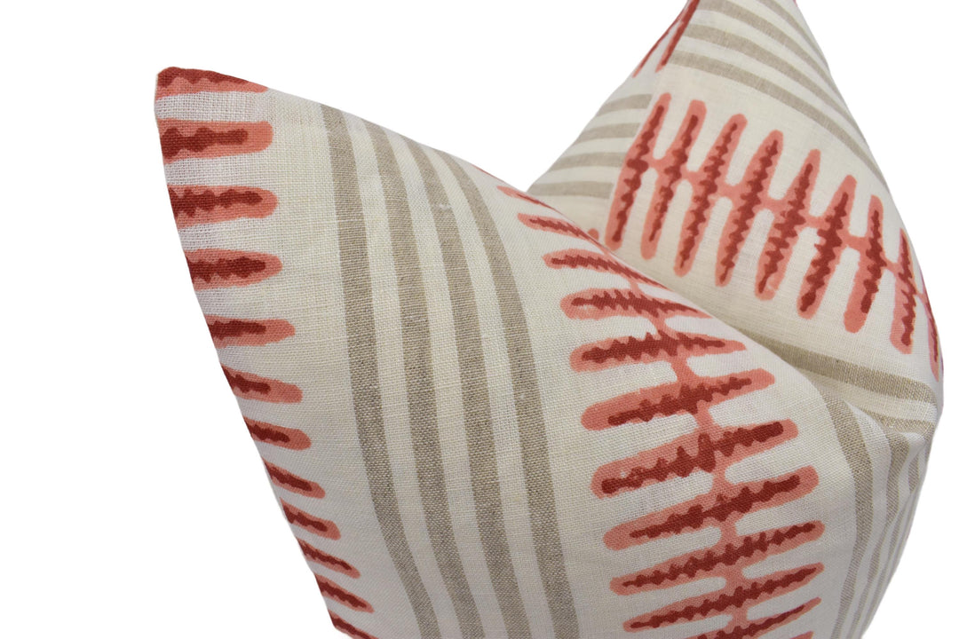 two decorative pillows with a striped pattern in shades of red and gray.