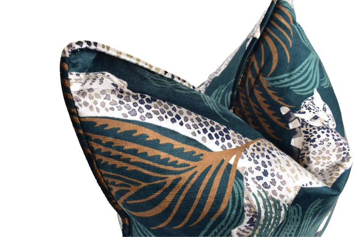 A close-up view of a decorative pillow with a leopard print pattern in shades of green, blue, and brown.