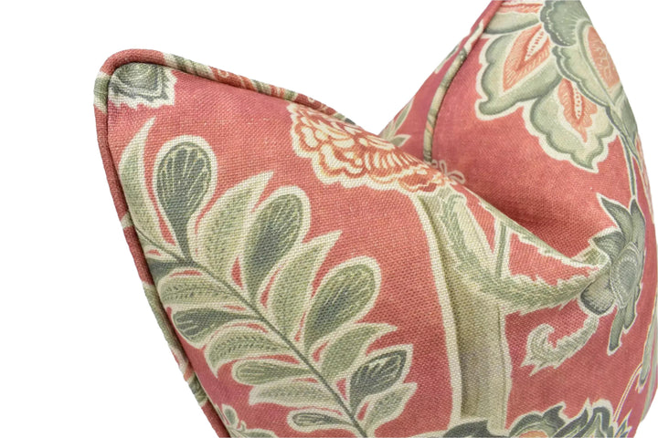 a close-up view of a decorative pillow with a floral pattern in shades of red, green, and white.