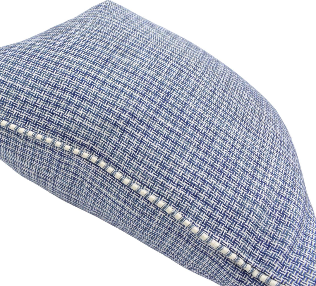 A close-up view of a blue and white checkered patterned pillow with a white stitching detail along the edge.