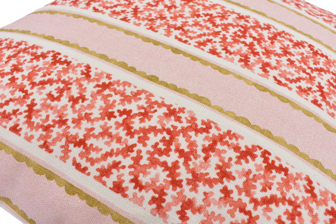 a close-up view of a decorative pillow with a floral pattern in shades of pink and red.