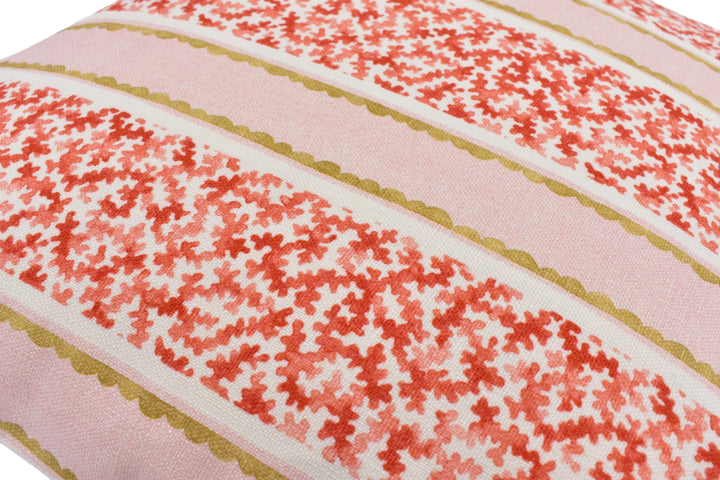 a close-up view of a decorative pillow with a floral pattern in shades of pink and red.