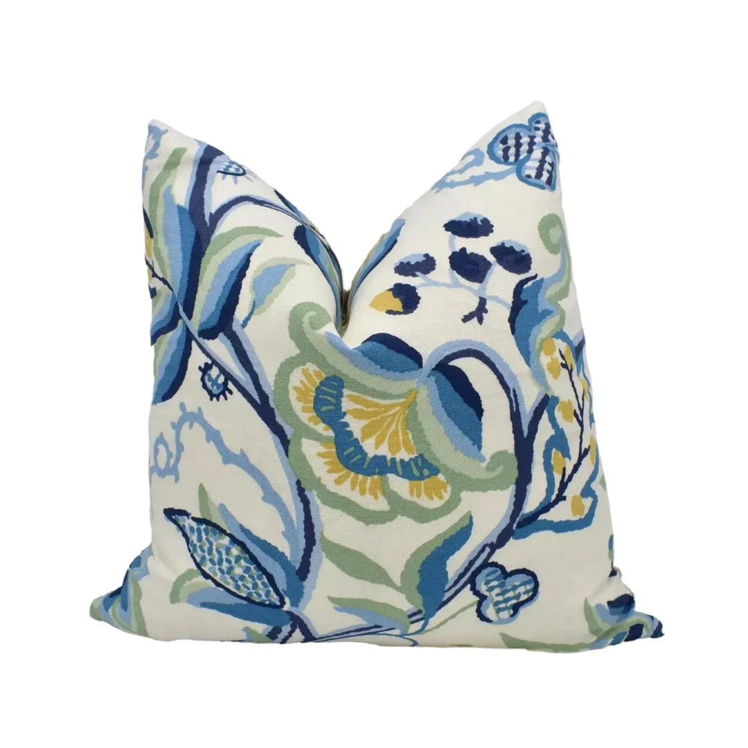 a decorative pillow with a floral pattern in shades of blue and green.
