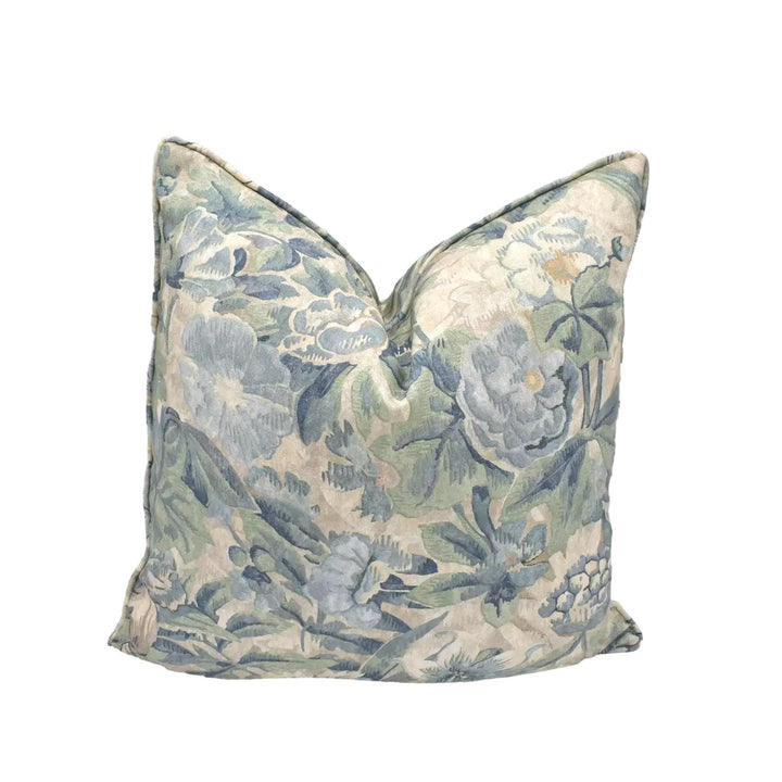 A decorative throw pillow with a floral pattern in shades of blue and green.