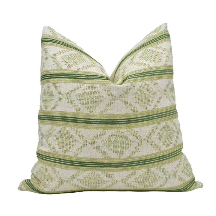 A decorative throw pillow with a repeating pattern of green and white diamond shapes.